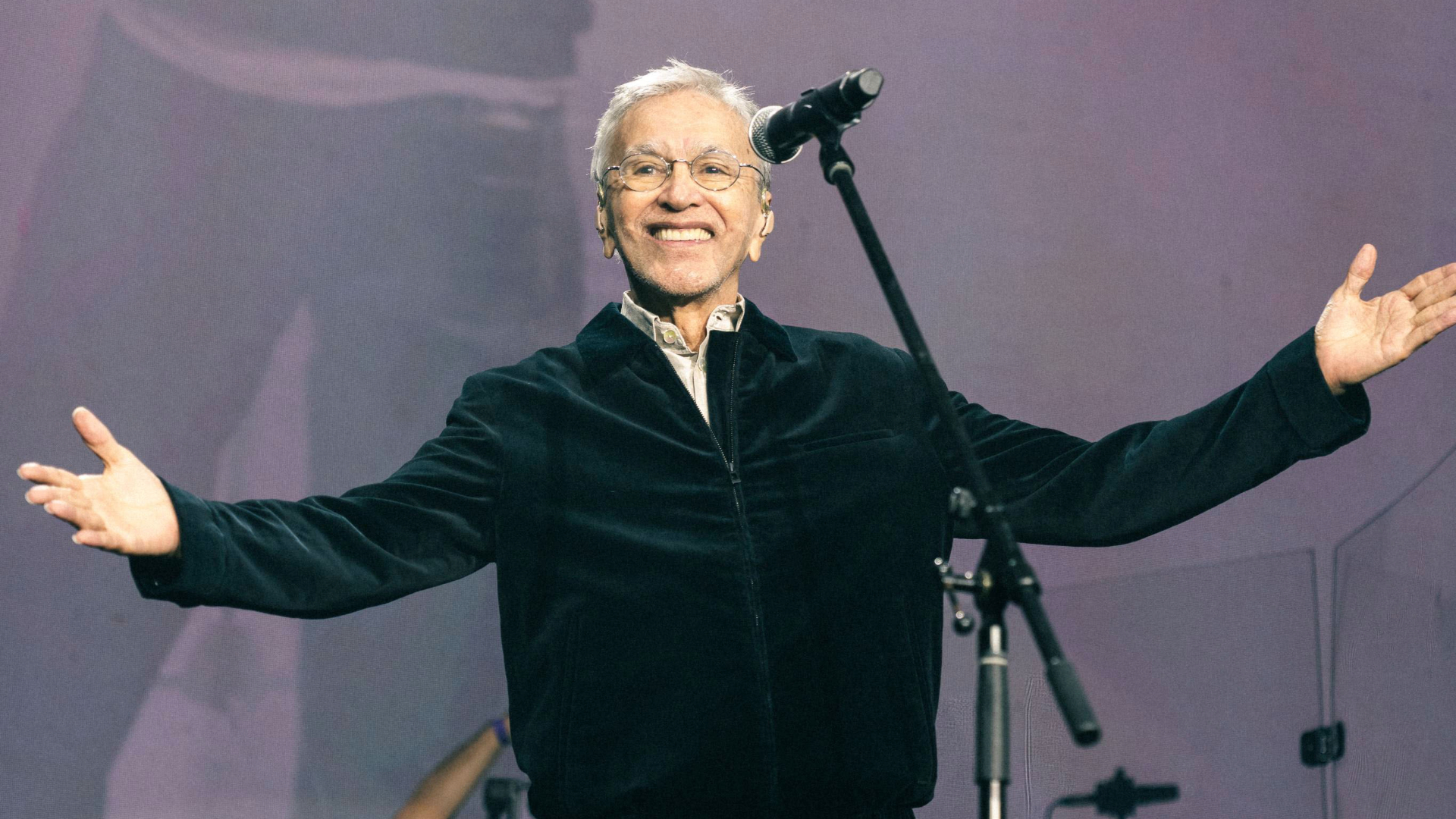 Caetano Veloso sorri e abre os braços durante show de reinauguração do Cine Lido, em Curitiba.