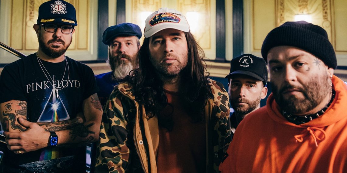 Os cinco integrantes do Alexisonfire posam juntos em fotografia promocional, usando bonés, gorros e roupas casuais, em um ambiente interno.